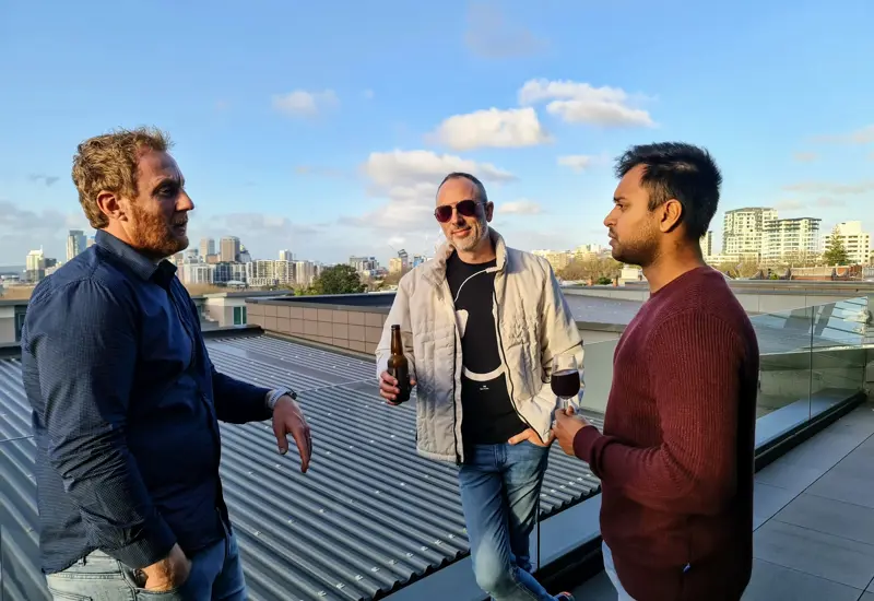 sandfield team on balcony with drinks