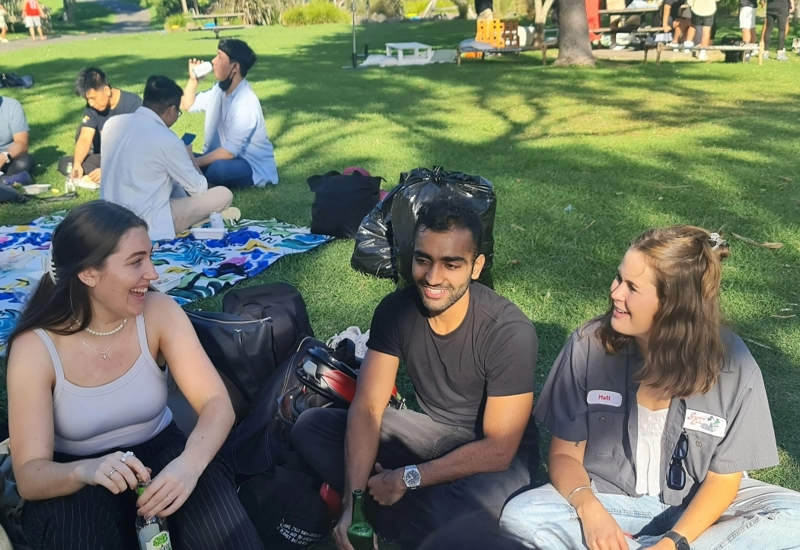 man and two women sitting in park