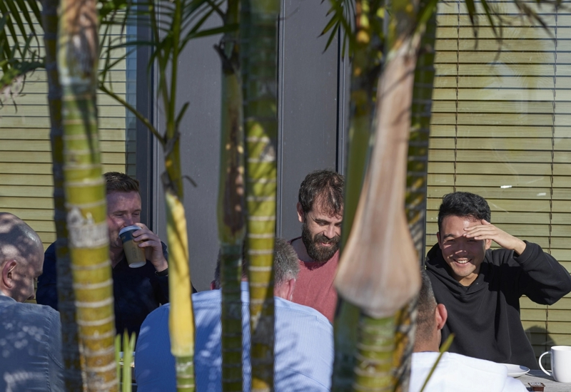 palm trees in front of people outside having coffee